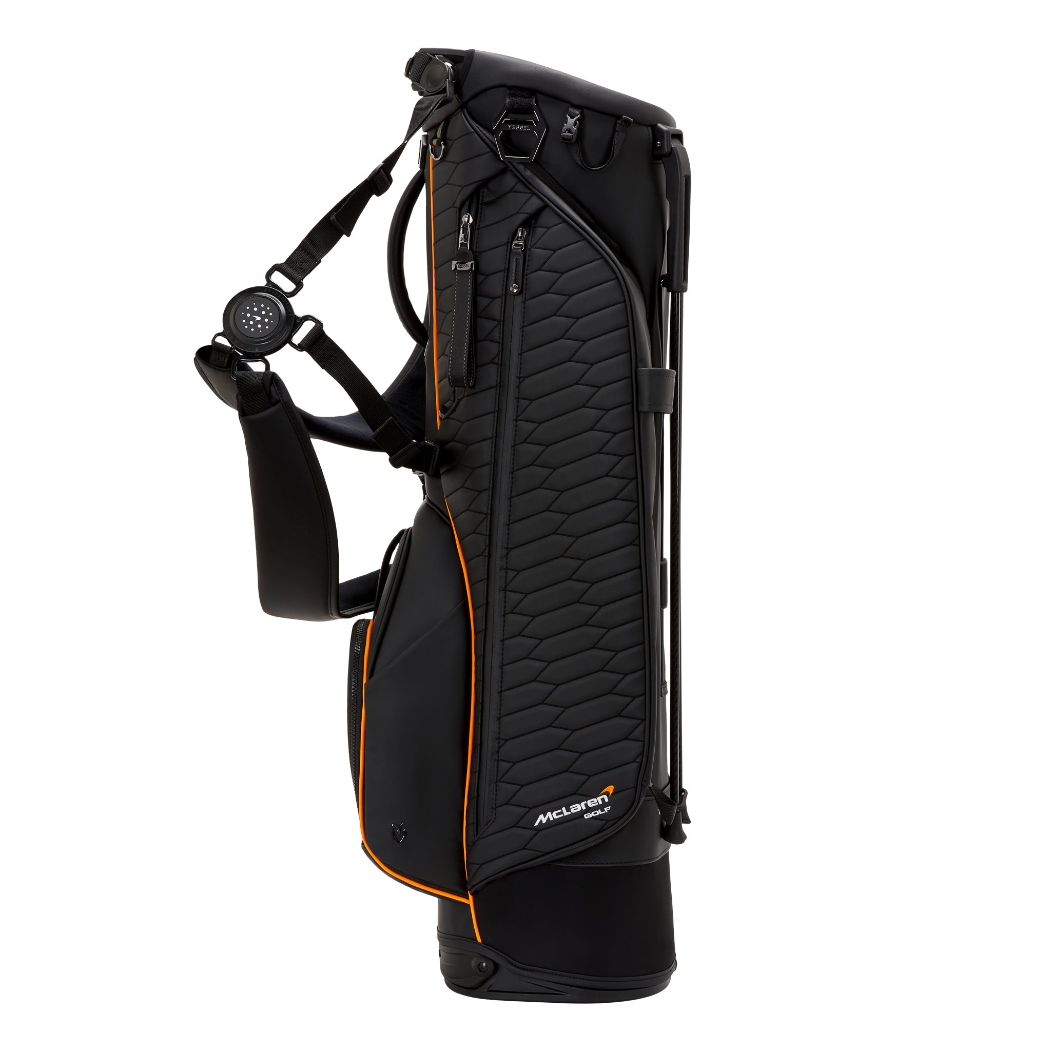 Lando Norris in a McLaren team polo standing next to a carbon-fiber Vessel golf bag.